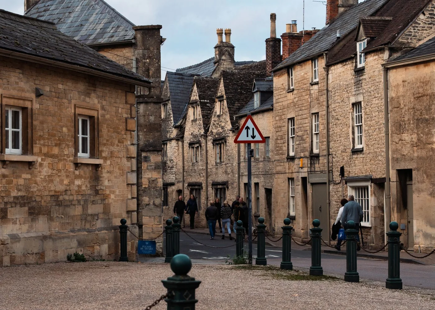 Honey-coloured stone houses along an English village street.