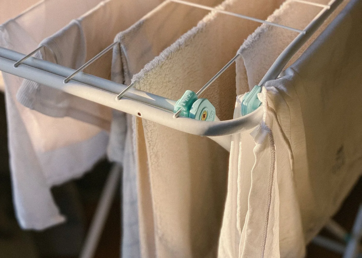 White laundry drying on a folding indoor rack.