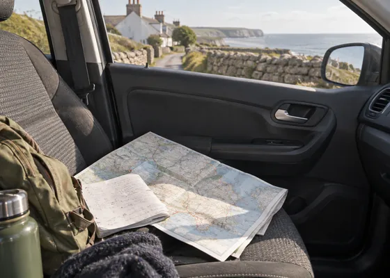 Paper directions and a map on a car passenger seat.