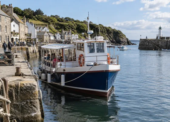 Small passenger sightseeing boat tied at a harbour quay.