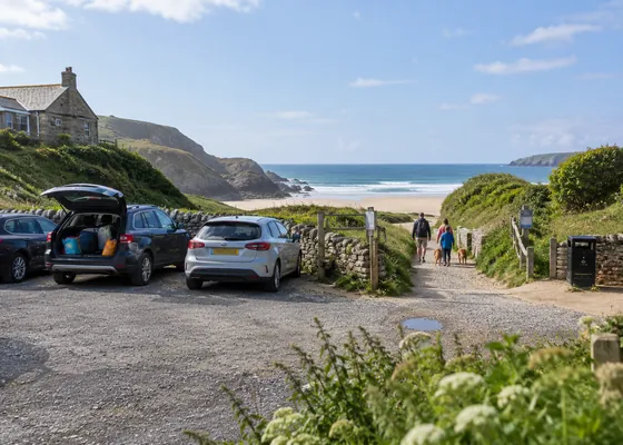 Coastal car park beside a path towards the beach.