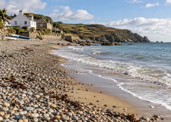 British shingle beach meeting a strip of sand at the water.