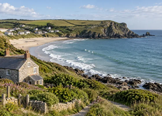 Curved bay with sandy shore and rocky headland.