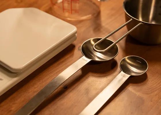 Kitchen utensils and a baking dish on a wooden worktop.