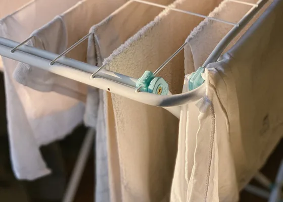 White laundry drying on a folding indoor rack.