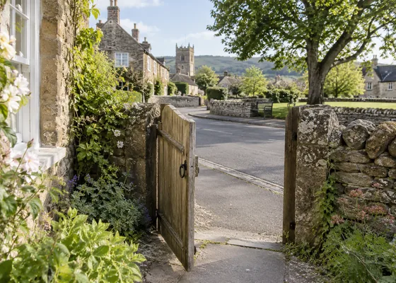 Cottage gate opening onto a village pavement.